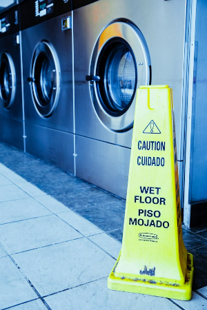 A wet floor sign in a laundromat.